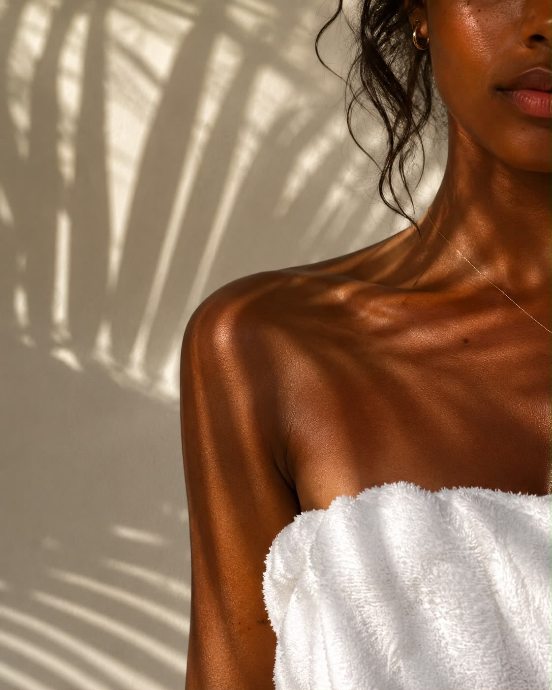 Gebronsde huid in warm zonlicht met palmschaduw